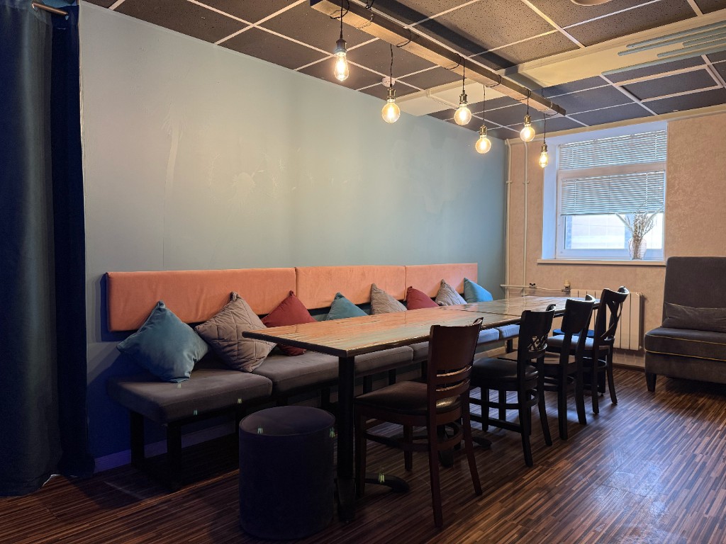 Уютная посадка с длинным столом и мягкой зоной в студии